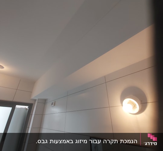 קיר גבס עם תאורה ומראה בחדר אמבטיה
